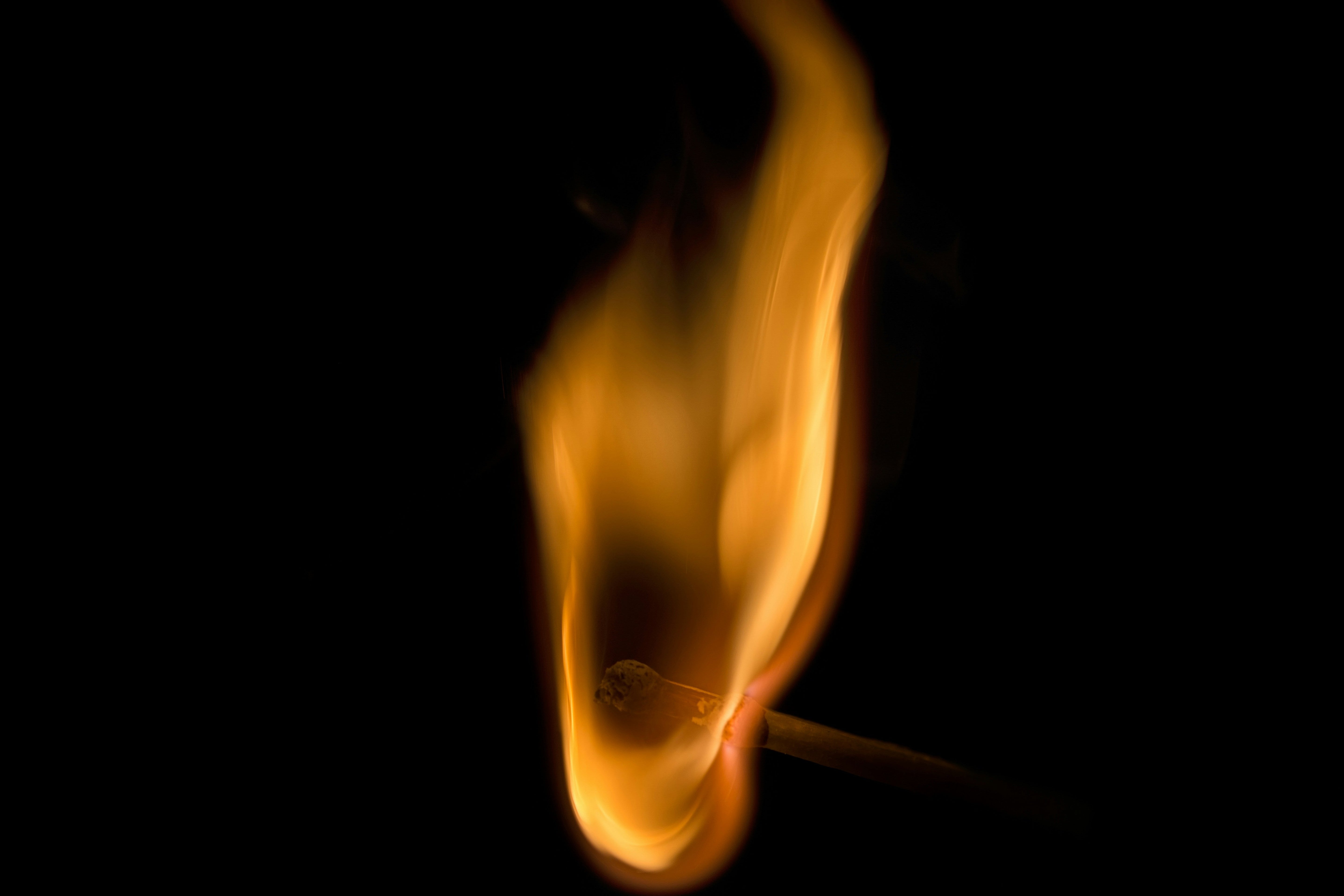flame on a match stick with dark background